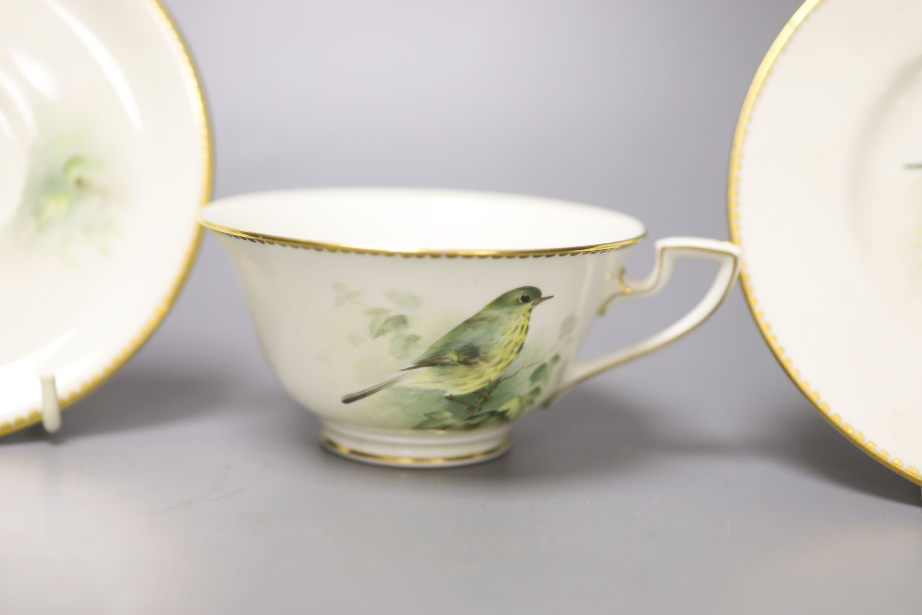 A Royal Worcester teacup, saucer and side plate, each unusually painted with a thrush on a branch by E. Townsend, signed black mark,